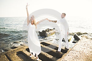 Happy romantic fashion couple in love have fun on beautiful sea at summer day