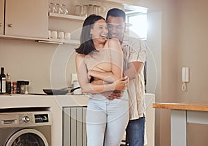 Happy, romantic and in love couple smiling, hugging and embracing while relaxing together indoors at home. Young, loving