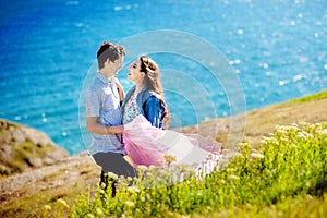 Happy romantic loving couple at the lake hugging and looking away love and relationships concept