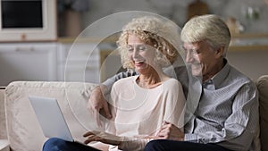 Happy romantic mature couple relaxing on home couch together