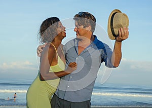 Happy and romantic mixed race couple with attractive black African American woman and Caucasian man playing on beach having fun