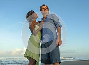 Happy and romantic mixed race couple with attractive black African American woman and Caucasian man playing on beach having fun