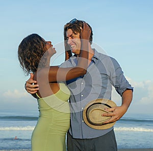 Happy and romantic mixed race couple with attractive black afro American woman and white man playing on beach having fun enjoying