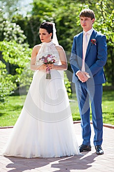 Happy, romantic newlywed couple posing in sunny park