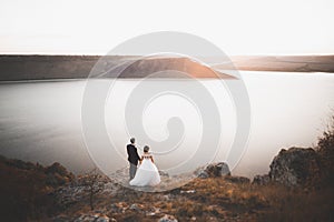 Happy and romantic scene of just married young wedding couple posing on beautiful beach