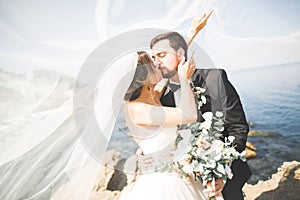 Happy and romantic scene of just married young wedding couple posing on beautiful beach