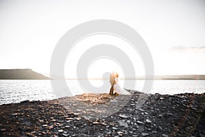 Happy and romantic scene of just married young wedding couple posing on beautiful beach