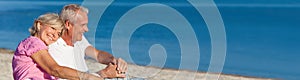 Happy Romantic Senior Couple Sitting Together on Beach photo