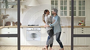 Happy romantic young couple husband and wife dancing in kitchen