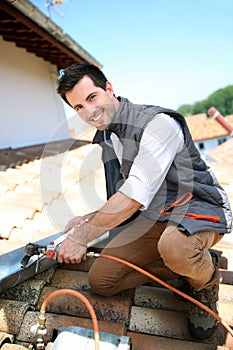 Happy roofer working on house