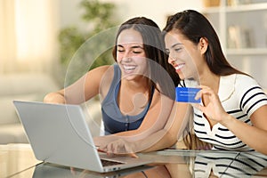 Happy roommates buying online at home photo