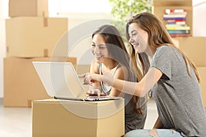 Happy roommates searching on line and moving home photo