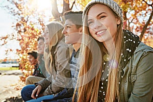 Happy, row and friends outdoor in park for relaxing day on summer vacation of semester break, together and bonding photo