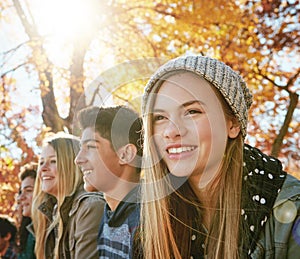 Happy, row and teenagers outdoor in park for relaxing day on summer vacation of semester break, together and bonding photo