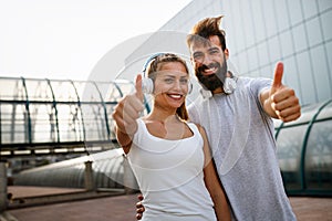 Happy runner couple exercising outside as part of healthy lifestyle. People sport running concept