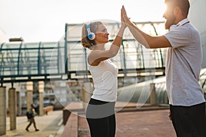 Happy runner couple exercising outside as part of healthy lifestyle. People sport running concept