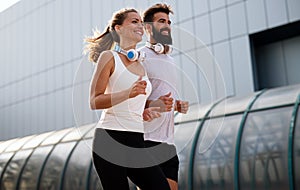 Happy runner couple exercising outside as part of healthy lifestyle. People sport running concept