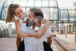 Happy runner couple exercising outside as part of healthy lifestyle. People sport running concept