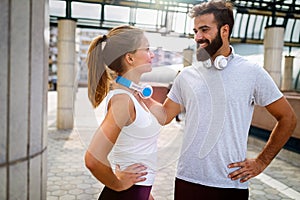 Happy runner couple exercising outside as part of healthy lifestyle. People sport running concept