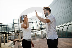 Happy runner couple exercising outside as part of healthy lifestyle. People sport running concept