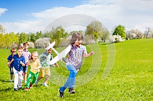 Happy running children with big white airplane toy