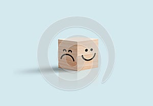 Happy and sad Face In Wooden Cube Business concept. Blue background. Positive negative feedback, customer review.