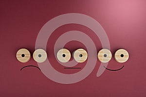 Happy and sad smiles on a wood circles on wood on a red