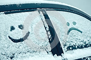 Happy and sad smiley emoticon face in snow