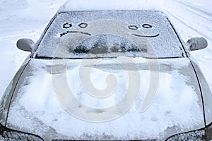 Happy and sad smiley emoticon face in snow on car windows, winter season joy and happiness concept