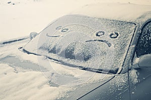 Happy and sad smiley emoticon face in snow on car windows, winter season joy and happiness concept