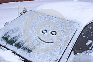 Happy and sad smiley emoticon face in snow on car windows, winter season joy and happiness concept