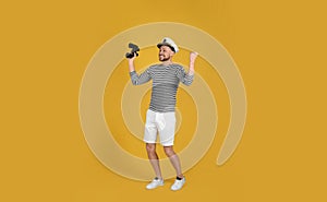 Happy sailor with binoculars on yellow background