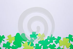 Happy Saint Patrick`s of handmade paper clover leaves on grey background