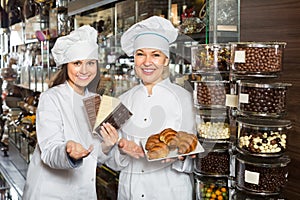 Happy saleswomen with chocolates