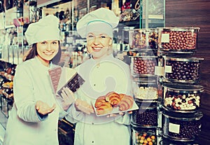 Happy saleswomen with chocolates photo