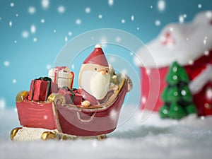 Happy Santa Claus with gifts box on the snow sled going to snow house. near snow house have Snowman and Christmas Tree.