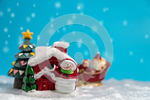 Happy Santa Claus with gifts box on the snow sled going to snow house. near snow house have Snowman and Christmas Tree. Santa Clau