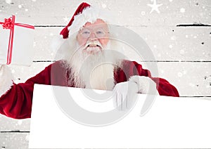 Happy santa claus holding blank placard and gift box