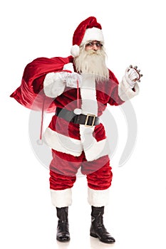 Happy santa claus holding red bag and ringing his bell