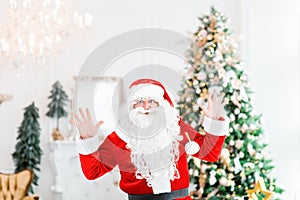 Happy Santa Claus indoors carrying no gifts to children