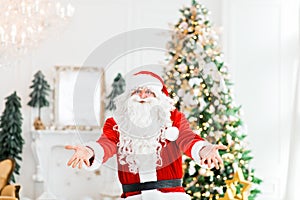 Happy Santa Claus indoors carrying no gifts to children