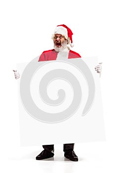 Happy Santa Claus pointing on blank advertisement banner background with copy space. Smiling Santa Claus pointing in