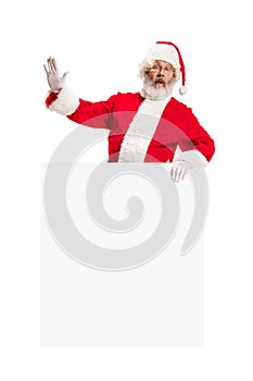 Happy Santa Claus pointing on blank advertisement banner background with copy space. Smiling Santa Claus pointing in