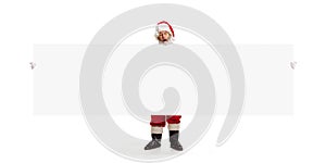 Happy Santa Claus pointing on blank advertisement banner background with copy space. Smiling Santa Claus pointing in