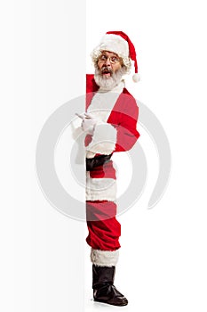 Happy Santa Claus pointing on blank advertisement banner background with copy space. Smiling Santa Claus pointing in