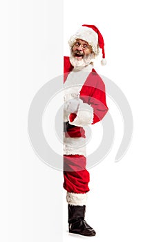 Happy Santa Claus pointing on blank advertisement banner background with copy space. Smiling Santa Claus pointing in