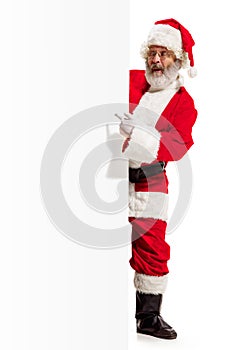 Happy Santa Claus pointing on blank advertisement banner background with copy space. Smiling Santa Claus pointing in