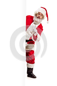 Happy Santa Claus pointing on blank advertisement banner background with copy space. Smiling Santa Claus pointing in