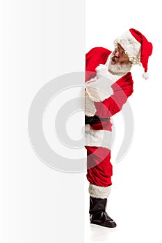 Happy Santa Claus pointing on blank advertisement banner background with copy space. Smiling Santa Claus pointing in