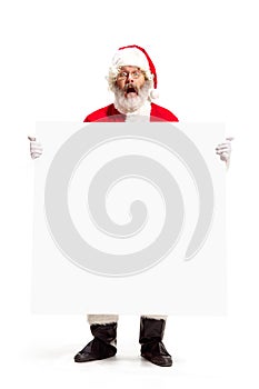 Happy Santa Claus pointing on blank advertisement banner background with copy space. Smiling Santa Claus pointing in